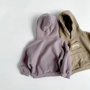 Flat lay view of kids fleece hoodies in purple and coffee with soft knit texture