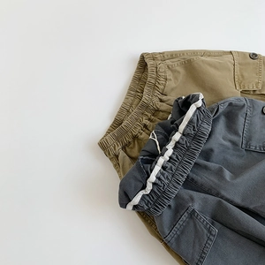 Macro detail of kids cargo pants showing elastic waistband and functional side pockets