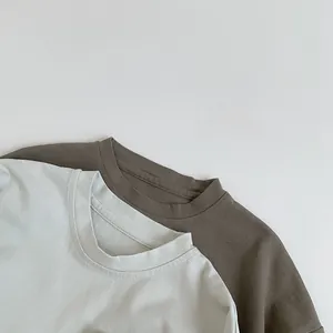 Gros plan de t-shirts en coton gris et vert olive montrant les détails du col rond