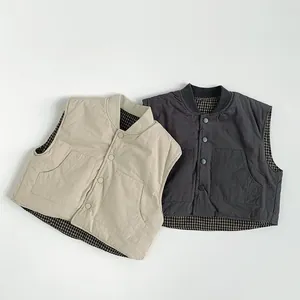 Detail view of quilted kids' vests with large pockets and checkered inner lining pattern