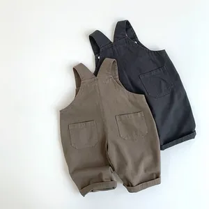 Flach liegende Baby-Latzhosen aus Baumwolle in Dunkelgrau und Khaki mit großen Taschen