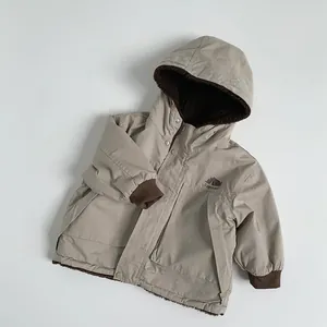 Dettaglio del parka per bambini con calda fodera in pile marrone e stampa camping