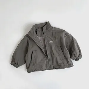 Close-up of gray-green children jacket with G-Sun 7 logo and elastic cuffs detail