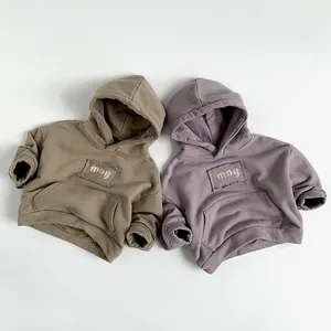 Detail of children's fleece hoodies with ribbed cuffs and may patch embroidery
