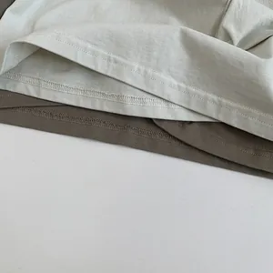 Détail de l'ourlet du t-shirt en coton avec double couture et tissu superposé de qualité
