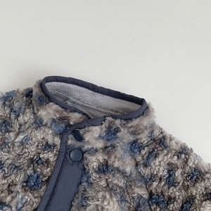 Detail view of blue sherpa fleece baby jacket with snap buttons and stand collar