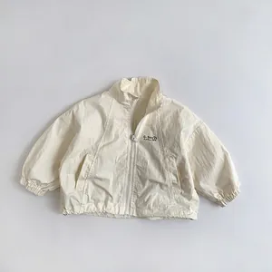 Detail of white children's windbreaker jacket showing zip collar and G-Sun print