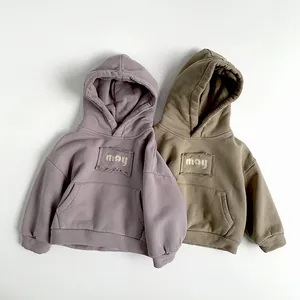Detail view of two fleece-lined hoodies in lilac and olive green with may embroidery