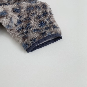 Detail of curly leopard fleece texture with durable navy blue elastic cuff stitching