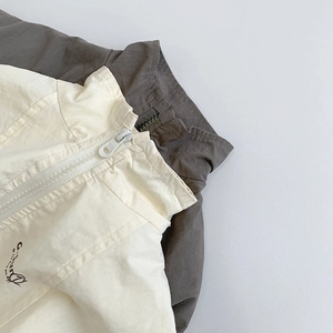 Close-up of children windbreaker collar with zipper detail in beige and charcoal