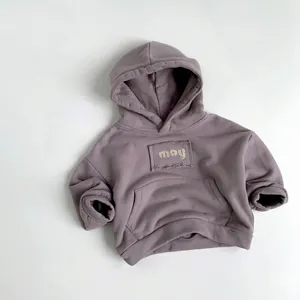 Macro detail of children hoodie showing the frayed may patch and ribbed sleeve cuffs