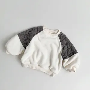 Detail of diamond-quilted shoulder stitching on a fleece-lined kids' sweatshirt