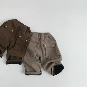 Detail of fleece-lined kids cargo pants in brown and khaki with large flap pockets