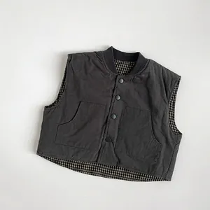 Detail view of kids reversible plaid vest with gray fabric and snap buttons
