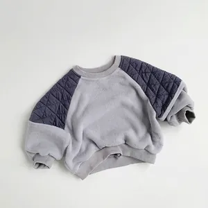 Detail of children's fleece sweatshirt showing navy quilted raglan sleeves and gray texture