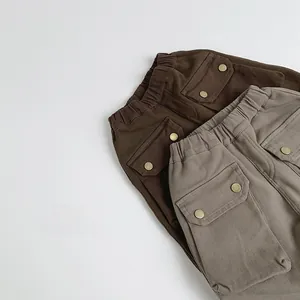 Flat lay of kids thermal cargo pants in brown and grey with large side pockets