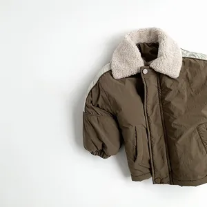 Detailed close-up of brown winter coat with fleece collar and September text print