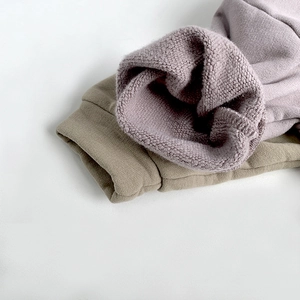 Close-up of ribbed cuffs on purple and olive green fleece hoodies with soft inner lining