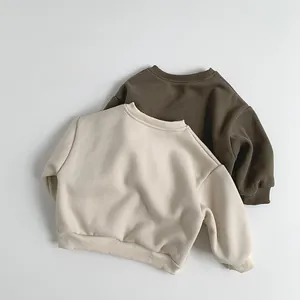 Close-up of beige and olive green fleece sweatshirts with ribbed cuffs for children