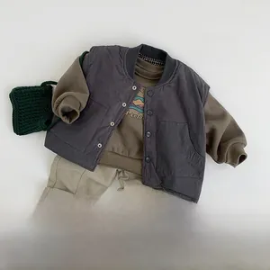 Flat lay of kids quilted vest, brown printed sweatshirt, khaki trousers and sneakers