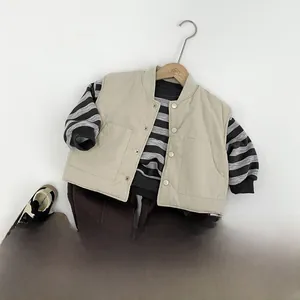 Flat lay of striped sweatshirt with beige utility vest and brown joggers set for kids