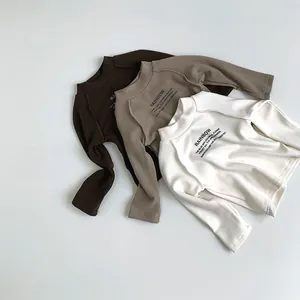 Détail à plat de hauts thermiques pour enfants aux tons terreux et col montant doux
