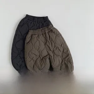 Detail of kids wave-quilted thermal pants with elastic cuffs in black and dark brown colors