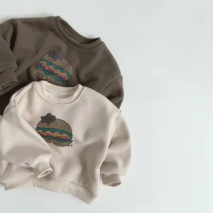 Flat lay of brown and beige fleece-lined sweatshirts with burger print and Food Colors text