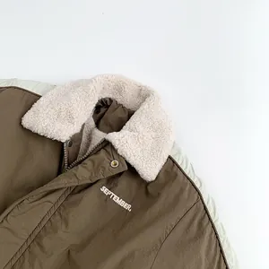 Detail of winter jacket featuring beige faux-shearling collar and September embroidery