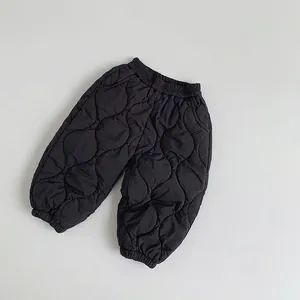 Close-up of black quilted children pants featuring elastic waistband and wavy texture