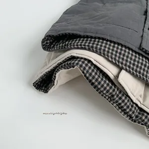 Detailed close-up showing the soft quilted texture and plaid lining of the padded vest