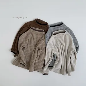 Close-up of ribbed knit texture on kids long sleeve tops in earthy colors with contrast trim