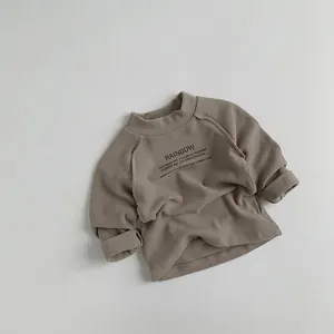 Détail d'un pull enfant à col montant en tissu taupe avec imprimé graphique arc-en-ciel