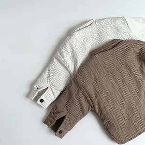 Detail of quilted cotton shirts for kids featuring textured pleated fabric and button cuffs