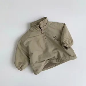 Detail of light khaki kids fleece sweatshirt with half-zipper and Pluto chest embroidery