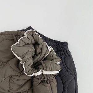 Detail of onion quilted kids warm pants with elastic waistband and contrast piping