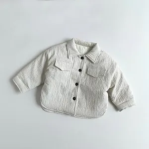 Detail of kids quilted beige corduroy jacket showing collar, buttons, and texture