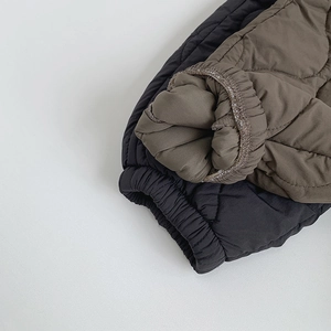 Detail view of elastic cuffs and quilted texture on lightweight children winter pants