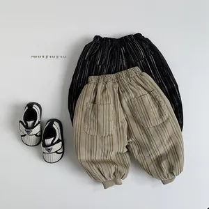 Detailed view of kids corduroy pants with elastic waistband and striped soft sole shoes