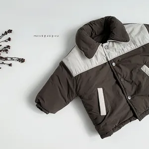 Détail d'une doudoune d'hiver pour enfants avec col contrasté et poches en marron