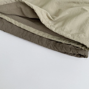 Detailed close-up of double-layer windproof fabric with warm fleece lining for kids sweater