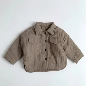 Close-up of children brown quilted shirt jacket with pleated texture and dual chest pockets