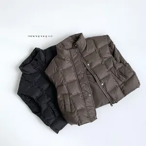 Detailed close-up of square-quilted puffer vests in black and dark brown with metal snaps