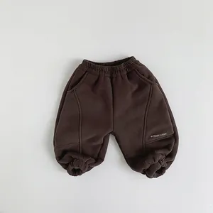 Detail of kids brown fleece joggers with elastic waist and Study Hard text print