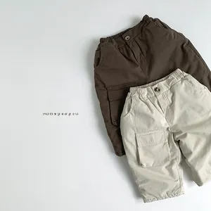 Close-up of kids' winter cargo pants with elastic waist and side pockets in brown and cream
