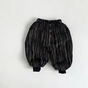 Detail of children corduroy pants featuring elastic waist with decorative buttons