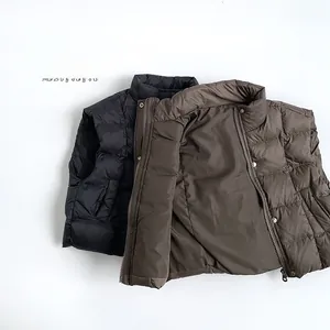 Detail of quilted winter vest with stand collar and snap buttons in black and brown