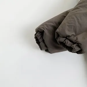 Détail du blouson d'hiver enfant marron foncé avec poignets élastiques et tissu matelassé