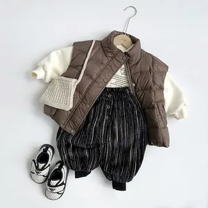 Kids quilted brown down vest with white hoodie and striped pants stylish winter outfit