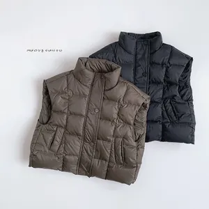Detail of kids puffer vests with square quilting and snap buttons in brown and black